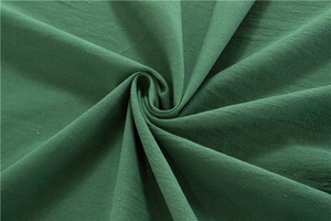 Macro detail of soft green washed cotton fabric texture with natural elegant pleats