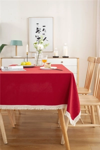 Detailed close-up of red washed cotton tablecloth featuring elegant white tassel fringes