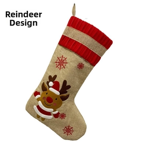 Detail of burlap Christmas stocking featuring a reindeer applique and red snowflakes