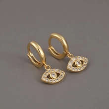 Detailed view of gold plated evil eye drop earrings with shimmering micro-pave zircons