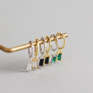 Detail of 925 silver hoop earrings with rectangular zircon stones in various colors