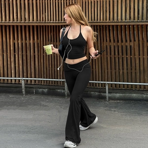 Detail shot of black halter crop top and low waist flared trousers on model outdoors