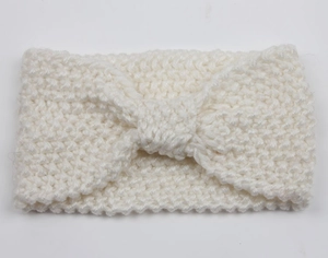 Close-up of white knit headband with chunky texture and a stylish bow knot design