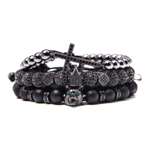 Detail of natural stone bracelets set featuring cross charm crown and wolf head bead