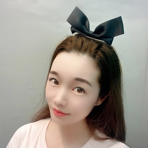 Close-up of a sweet black ribbon bow hair clip worn on a model for a stylish look