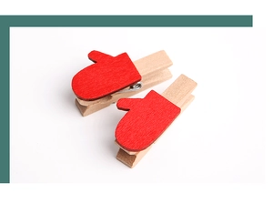 Detail shot of two mini wooden clips with red cartoon glove decor for Christmas photos