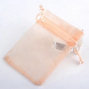 Close-up of peach chiffon organza gift bag with drawstring closure and mesh texture