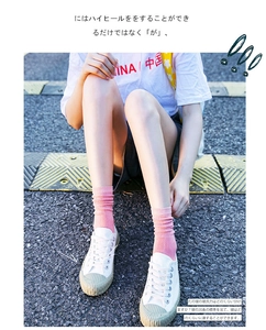 Pink cotton crew socks with ribbed texture worn by a model in white canvas sneakers