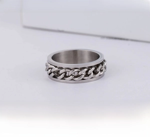 Macro detail of men's stainless steel rotating chain ring with silver finish