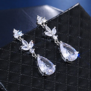 Macro shot of silver teardrop zircon earrings featuring pear-cut stones and leaf accents