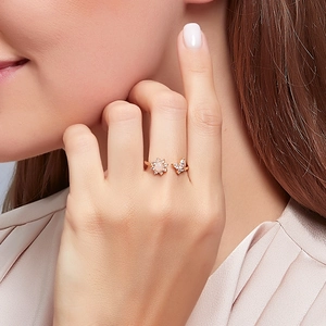 Close-up of rose gold butterfly and opal flower ring set with sparkling zircons
