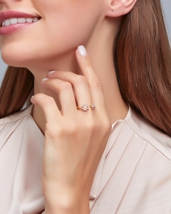 Close-up of golden sunflower ring with pink opal stone on female model's hand