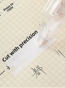 Close-up of a 78m large capacity white correction tape used on grid paper