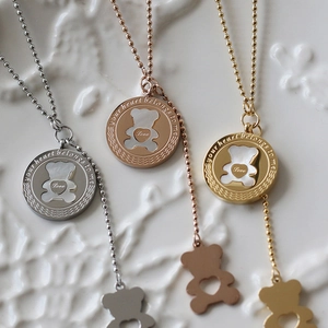 Detail of rose gold and silver bear necklaces with Love and your heart belongs to me engraving