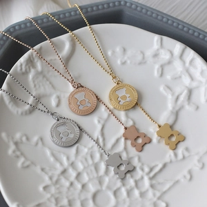 Detailed macro view of three heart bear necklaces in silver, gold, and rose gold finishes