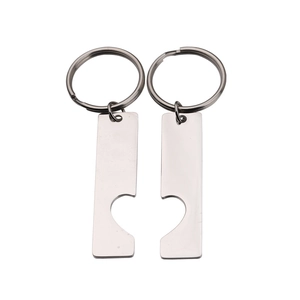 Detail of polished stainless steel heart puzzle keychain set for couples on white background
