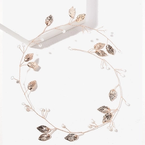 Detail of a flexible gold bridal hair vine with metallic leaves and crystal beads
