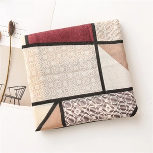 Detailed flat lay of geometric patchwork scarf with burgundy and beige earthy patterns