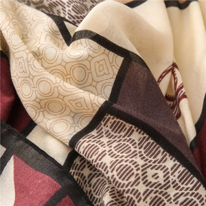 Close-up of soft linen-cotton scarf featuring abstract geometric patterns in warm earth tones