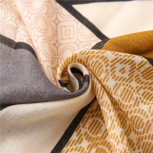 Macro view of geometric cotton-linen scarf showing yellow and grey abstract pattern textures
