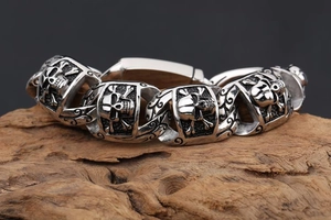 Macro view of vintage silver skull links on a heavy punk rock stainless steel bracelet