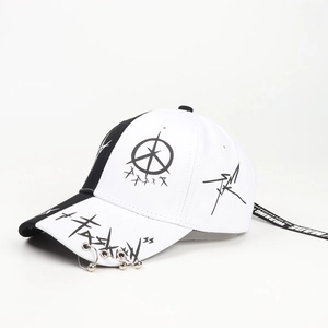 Detail of baseball cap showing silver metal rings on brim and graffiti print accents