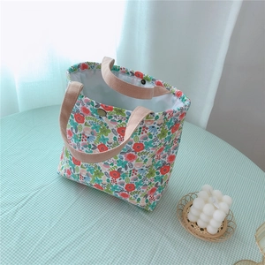 Detail of floral canvas lunch bag with reinforced handles and brass snap closure