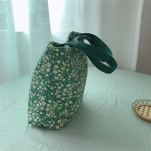 Detail of floral canvas tote bag with thick insulation and green webbing handles