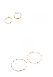 Close-up of polished stainless steel hoop earrings with elegant knot detail in gold finish