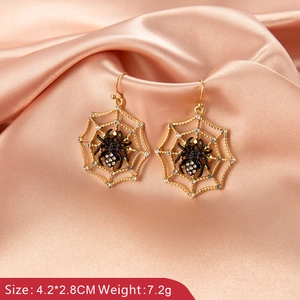 Detailed view of gold spider web drop earrings with black spider and white rhinestones
