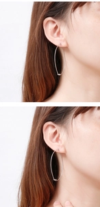 Detailed view of large silver twisted knot hoop earrings worn on a female model