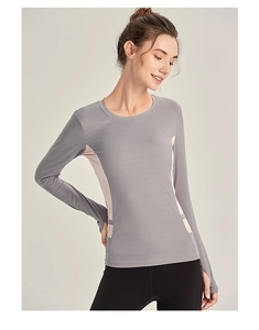 Détail du haut de fitness gris foncé avec panneaux roses et trous pour les pouces