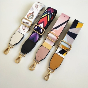Detail of four adjustable wide straps with colorful patterns and gold lobster clasps