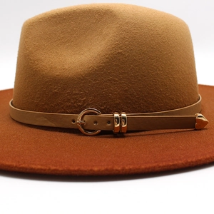 Detail of brown wool fedora hat featuring a slim leather band and golden metal buckle