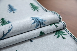 Detailed texture of grey chenille Christmas table runner with festive tree embroidery