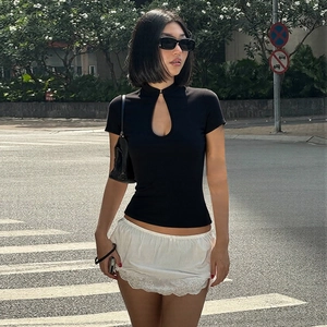 Vue détaillée du crop top noir ajusté avec découpe en goutte d'eau et bouton mandarin