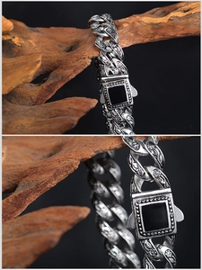 Detail of silver vintage Cuban chain with engraved patterns and square black resin stone