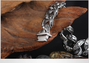Detail of vintage carved Cuban link chain with black resin stone and silver metallic texture