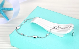 Detailed view of S925 silver heart bracelet with white rhinestones on blue gift box