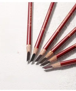 Flat blade eyebrow pencils in six shades with deep red wooden barrels on a textured base