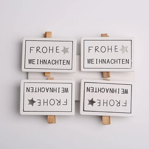 Set of four white wooden Christmas clips with Frohe Weihnachten text and star cutouts