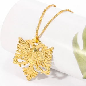 Détail du pendentif aigle albanais doré avec texture gaufrée et chaîne torsadée