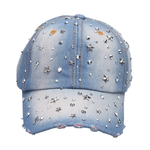 Detail of light blue denim baseball cap with silver metal star studs and distressed brim