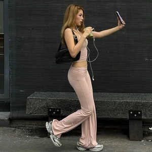 Close-up of pink crop halter top and flared pants set in a stylish outdoor setting