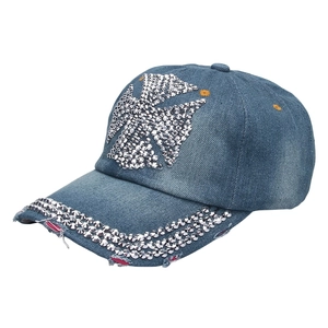 Detail of distressed denim baseball cap with silver rhinestone cross and frayed edge