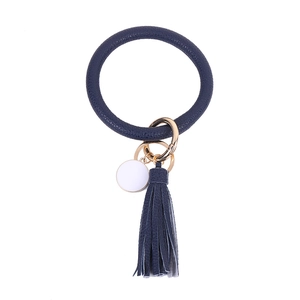 Detailed macro view of dark blue PU leather keychain ring with tassel and gold metal hardware