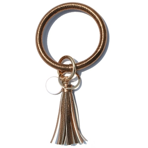 Dettaglio del portachiavi a bracciale in PU intrecciato bronzo con nappe metalliche