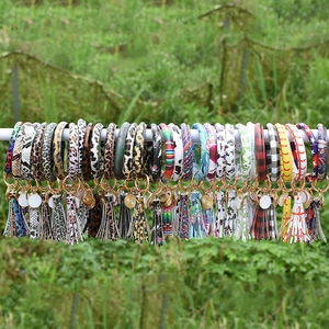 Close-up of various printed leather tassel wristlet keychains with metallic rings