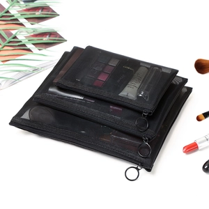 Three-piece set of black nylon mesh cosmetic bags in various sizes on white tabletop