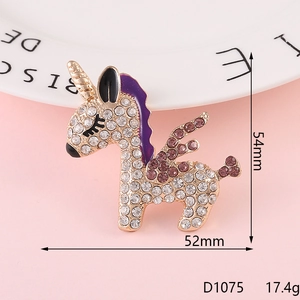 Golden unicorn brooch with pink and purple rhinestones on a decorative pink background